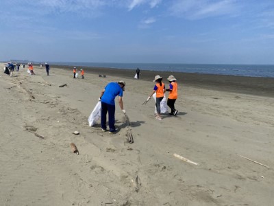 學童在老師與志工的帶領下，認真撿拾沙灘上的廢棄物